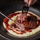 Person cutting into a 3-D printed plant-based steak